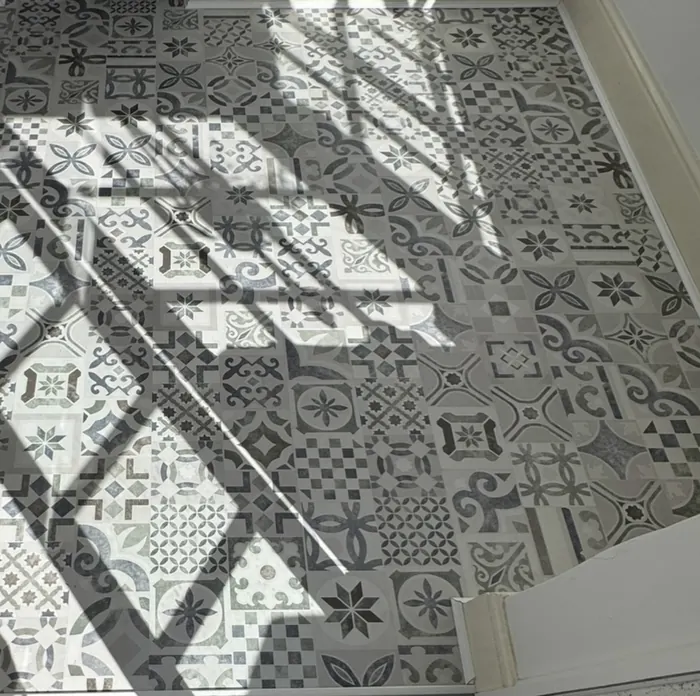 Close view of grey patterned laminate flooring supplied and fitted in Sherburn, with natural window shadows