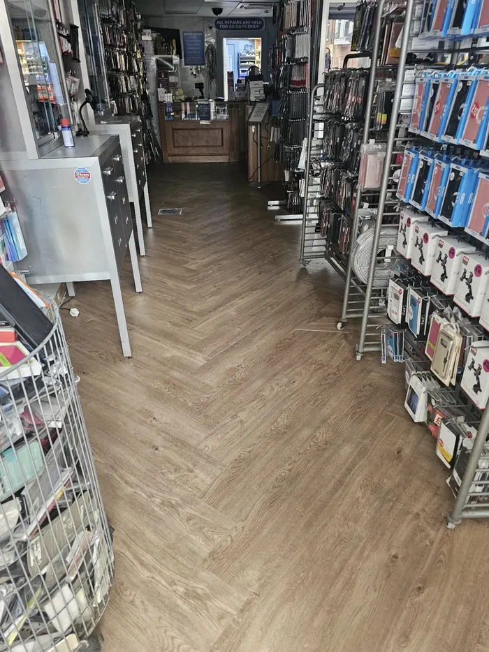 Wood-effect herringbone LVT through a Scarborough shop aisle between stocked display shelves